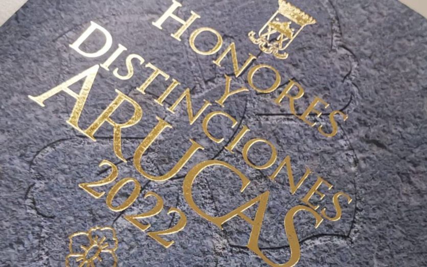 Portada de libro de Honores y Distinciones Arucas 2022, letras doradas sobre piedra