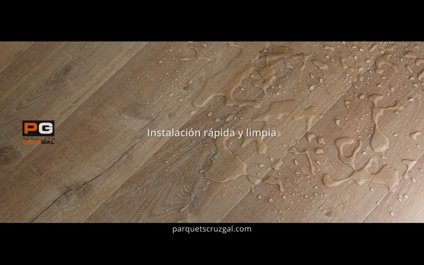 Fotograma de video para parquets CruzGal donde se ve un charco de agua sobre la madera.